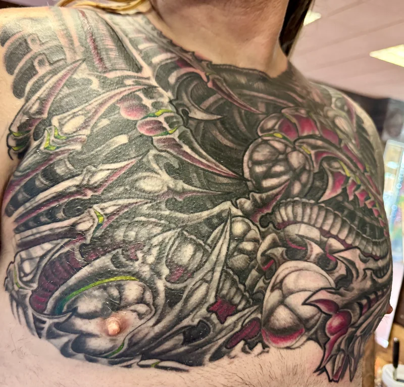 Biomechanical dragon chest tattoo by Aaron Sangenitto at Tattooz Ink in Redding, California